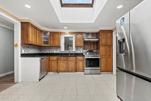 a kitchen with stainless steel appliances granite countertop a refrigerator and a stove top oven