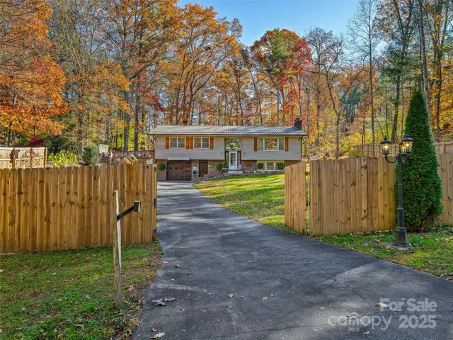 a view of a house with backyard and trees