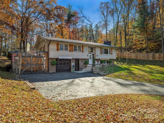 a front view of a house with a yard covered with snow and trees