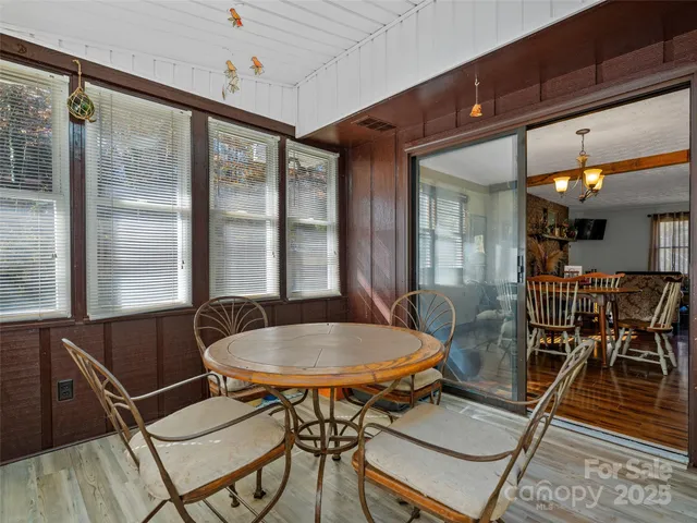 a dining room with furniture a chandelier and wooden floor