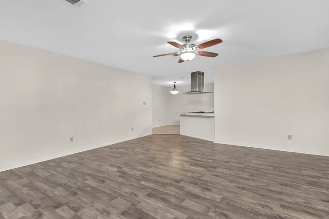 a view of a kitchen with wooden floor and a ceiling fan