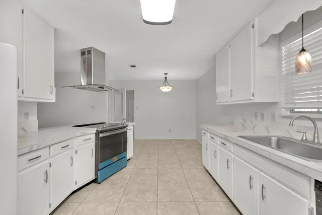 a kitchen with granite countertop a sink stainless steel appliances and cabinets