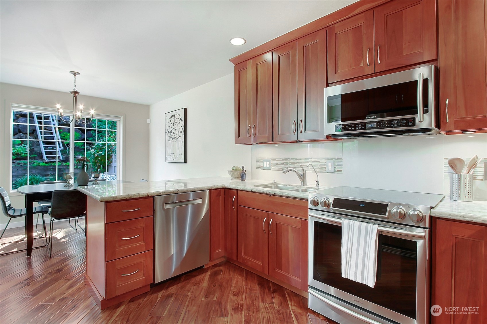 530 Elma Place Northeast Renton, WA 98059 - Photo 13 of 32 a kitchen with stainless steel appliances granite countertop wooden cabinets a stove a microwave and a wooden floors