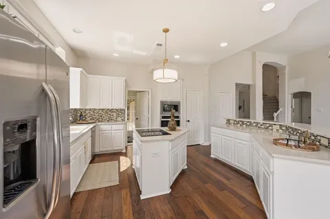 a kitchen with white cabinets and stainless steel appliances
