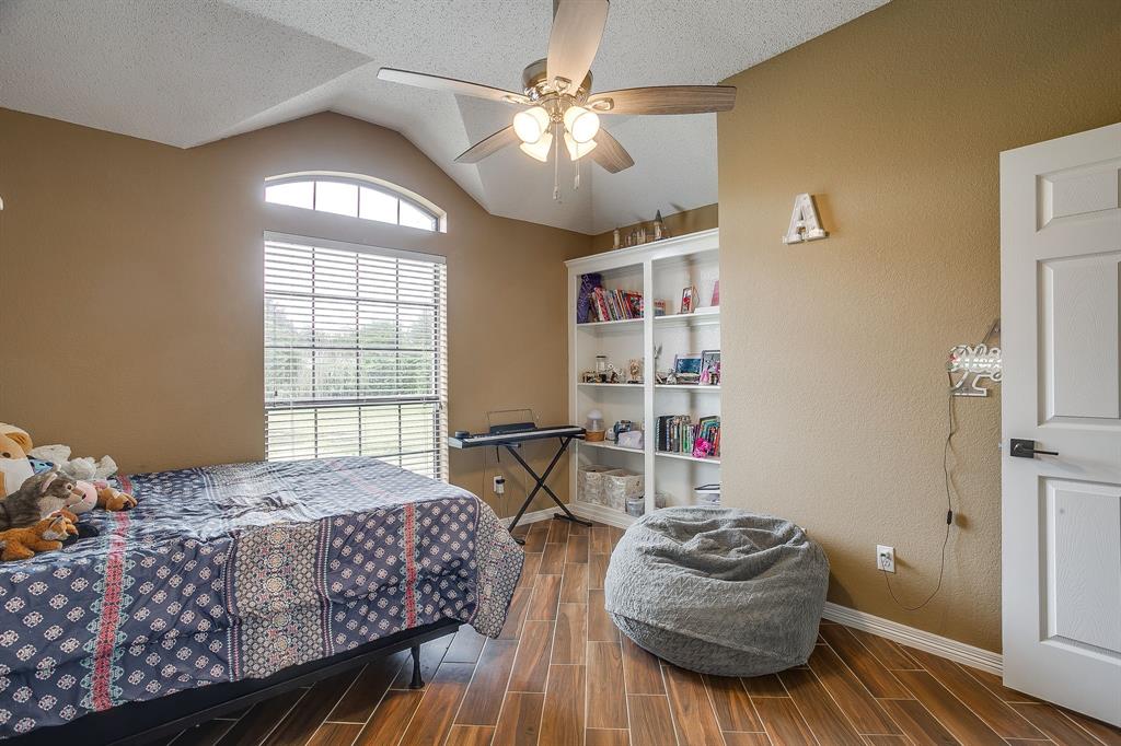 1050 Hampel Road Palmer, TX 75152 - Photo 31 of 35 a bedroom with a bed and a chandelier