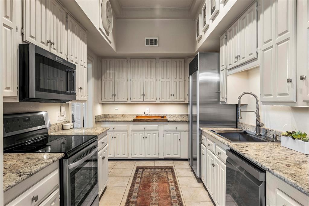 3424 Gillespie Street, Unit 5 Dallas, TX 75219 - Photo 12 of 31 a kitchen with stainless steel appliances granite countertop a sink stove and refrigerator