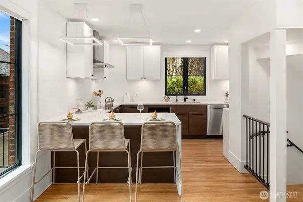 a kitchen with stainless steel appliances kitchen island granite countertop a table chairs sink and cabinets