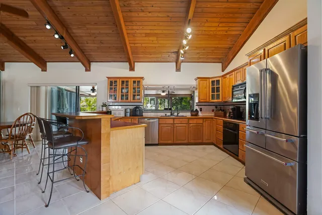 a kitchen with granite countertop a refrigerator and wooden cabinets