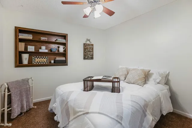 a bedroom with a bed and a painting on the wall