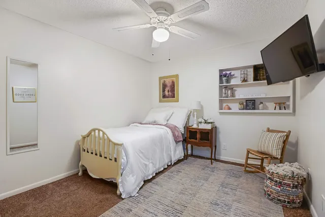a spacious bedroom with a bed and a flat screen tv