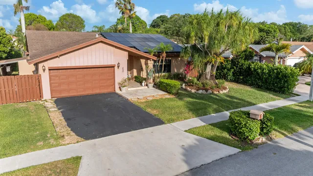 a front view of house with yard and trees in the background