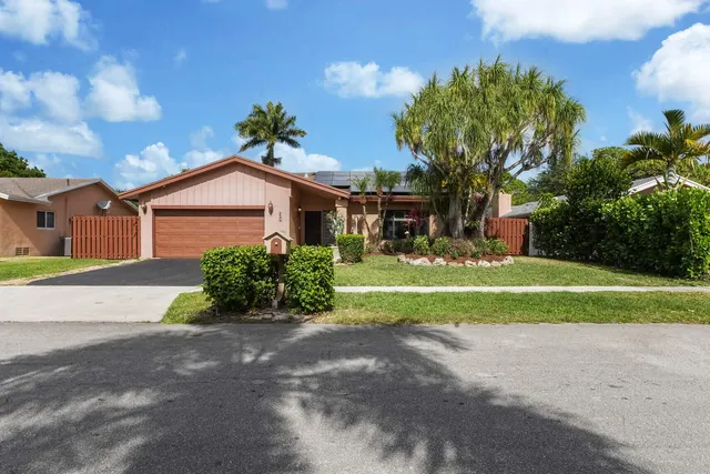 a front view of a house with a yard and a garage
