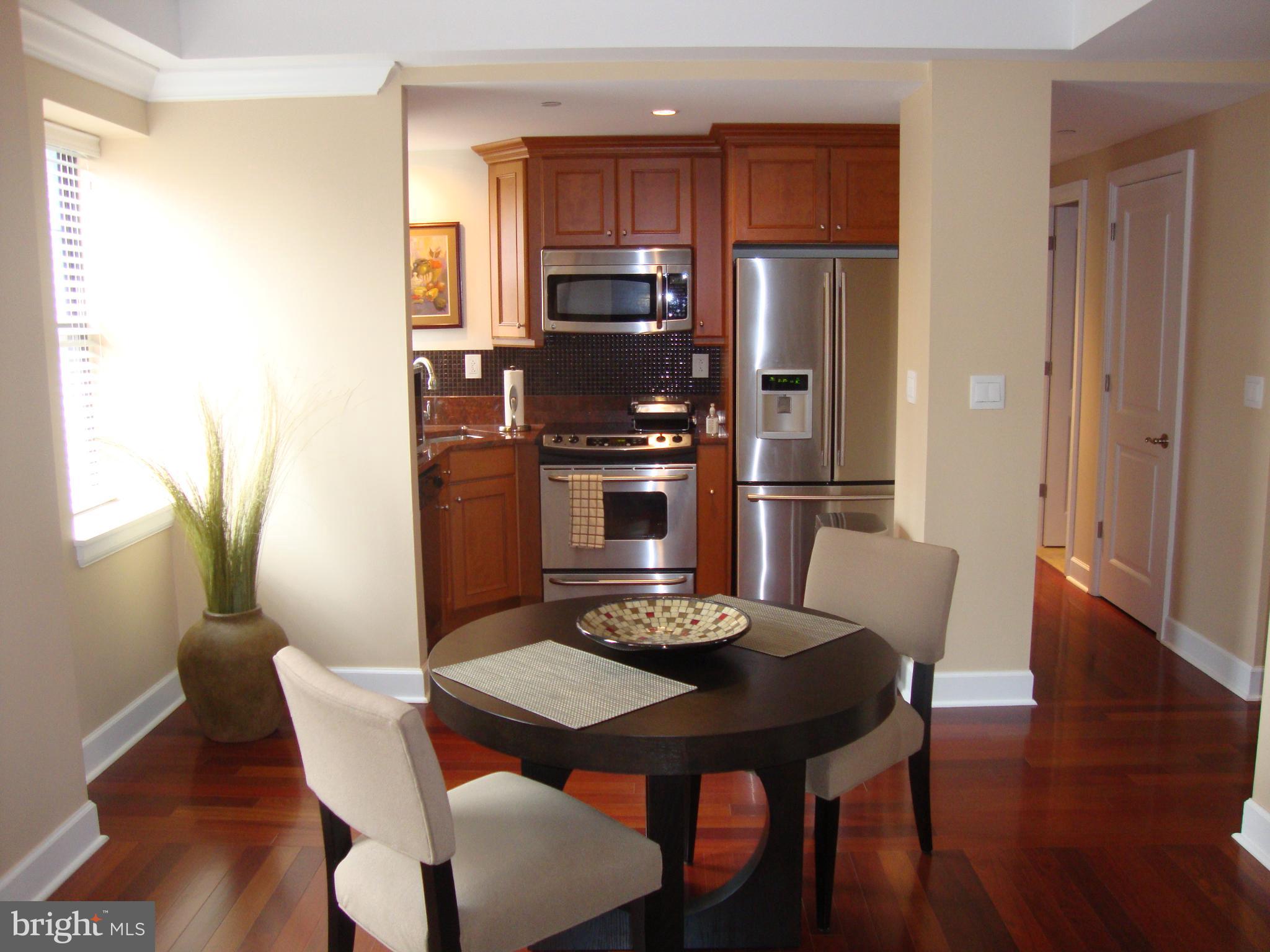 1701-15 Locust Street, Unit 1402 Philadelphia, PA 19103 - Photo 4 of 17 a kitchen with stainless steel appliances granite countertop a dining table and chairs