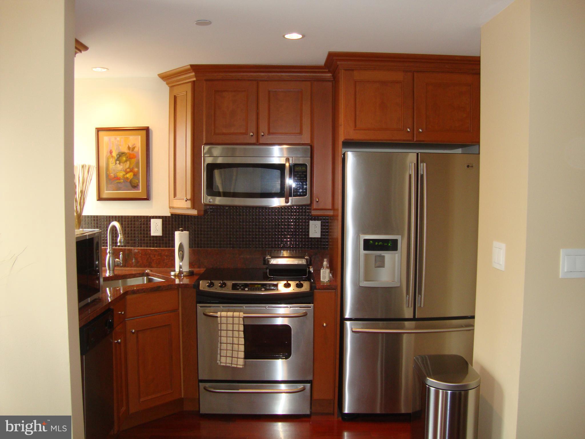 1701-15 Locust Street, Unit 1402 Philadelphia, PA 19103 - Photo 5 of 17 a kitchen with a refrigerator and a microwave