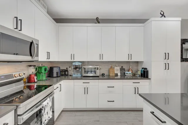 a kitchen with granite countertop white cabinets and white appliances