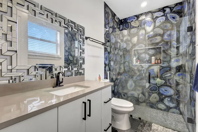 a bathroom with a granite countertop sink toilet and shower
