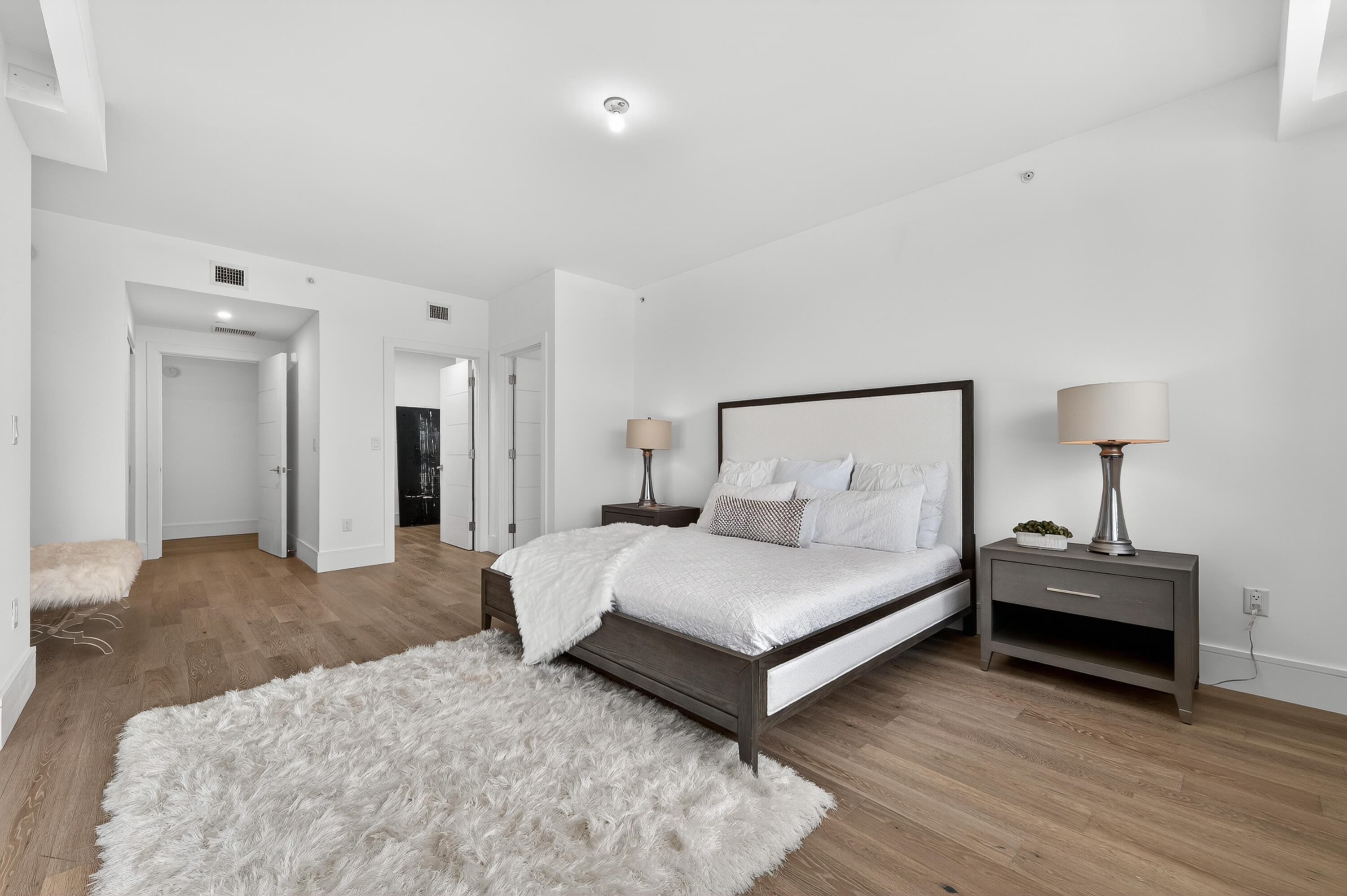 1 South Coastal Way, Unit 201 Jupiter, FL 33477 - Photo 16 of 40 a spacious bedroom with a bed and a lamp