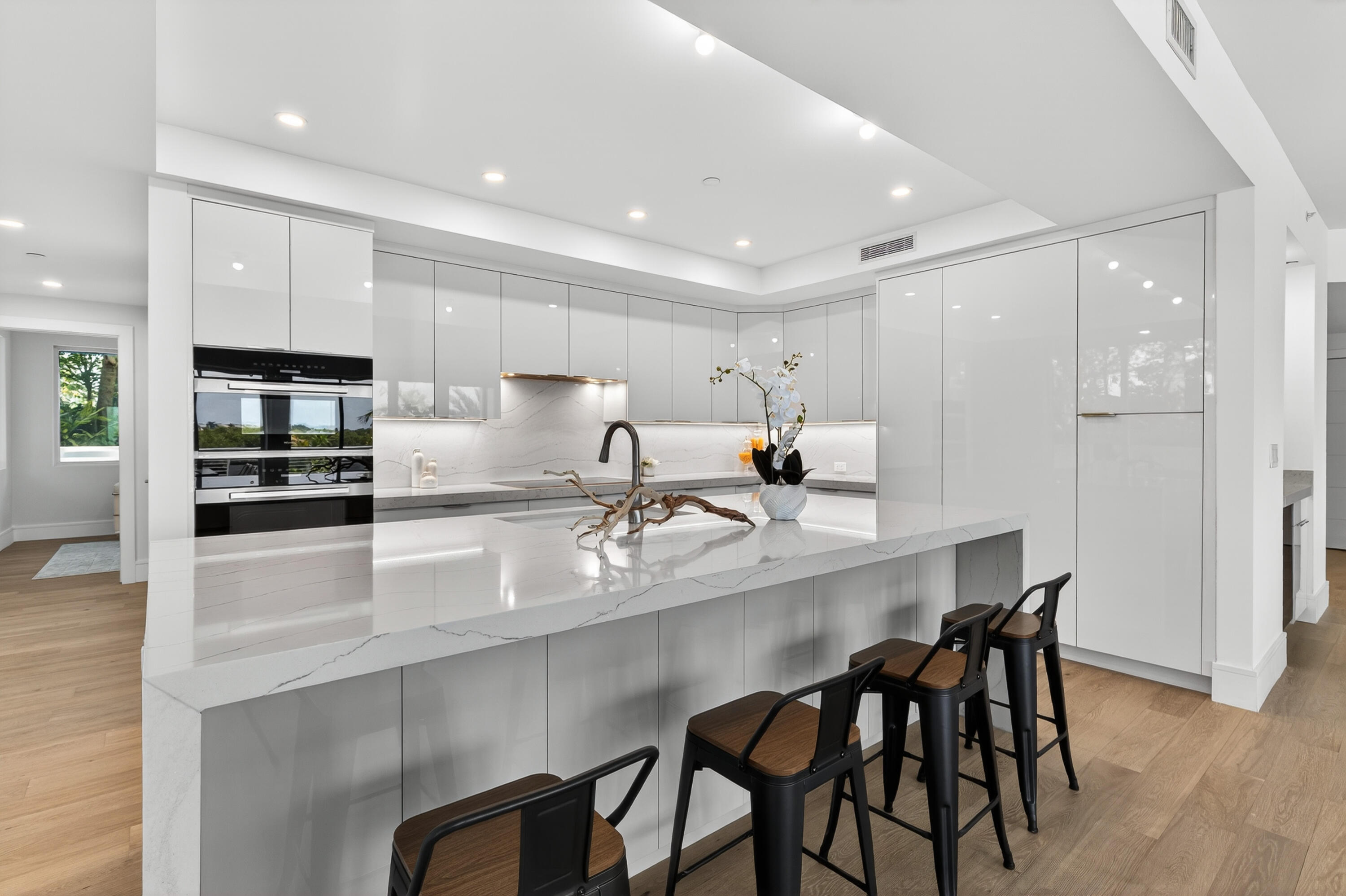1 South Coastal Way, Unit 201 Jupiter, FL 33477 - Photo 2 of 40 a kitchen with kitchen island cabinets and chairs in it