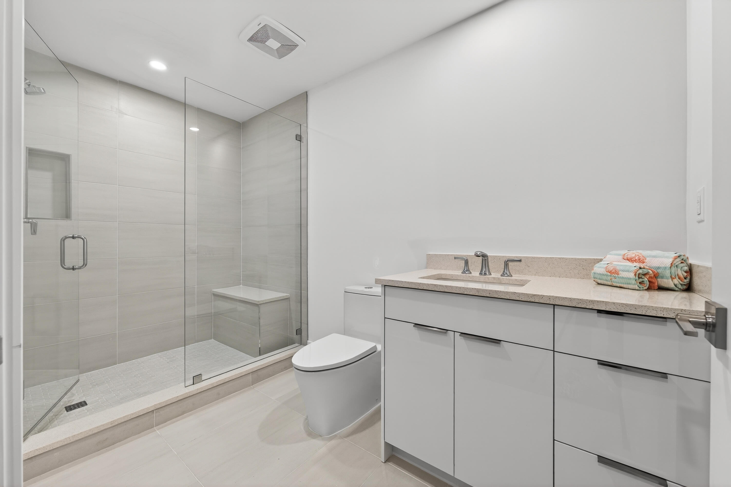 1 South Coastal Way, Unit 201 Jupiter, FL 33477 - Photo 24 of 40 a bathroom with a granite countertop sink a toilet and shower