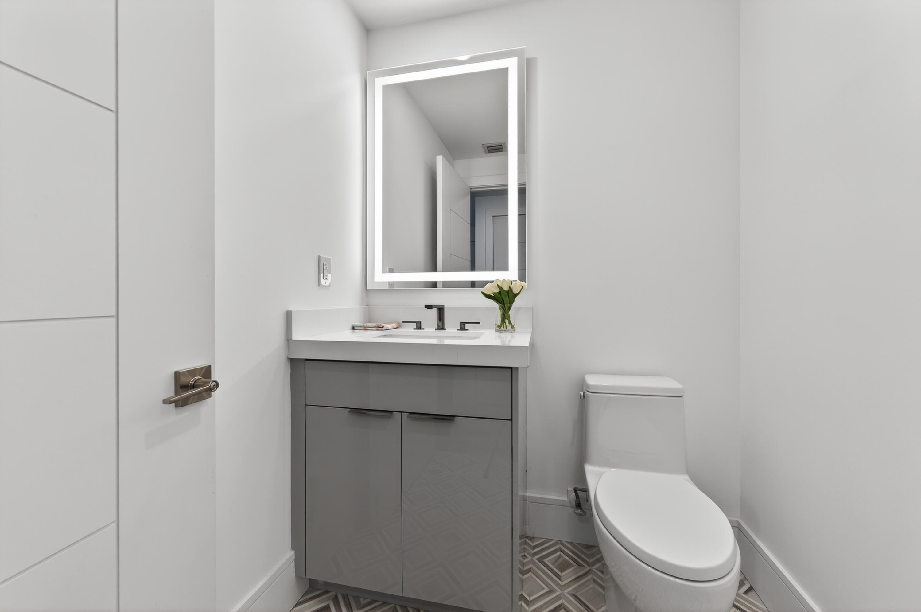 1 South Coastal Way, Unit 201 Jupiter, FL 33477 - Photo 26 of 40 a bathroom with a toilet a sink and mirror