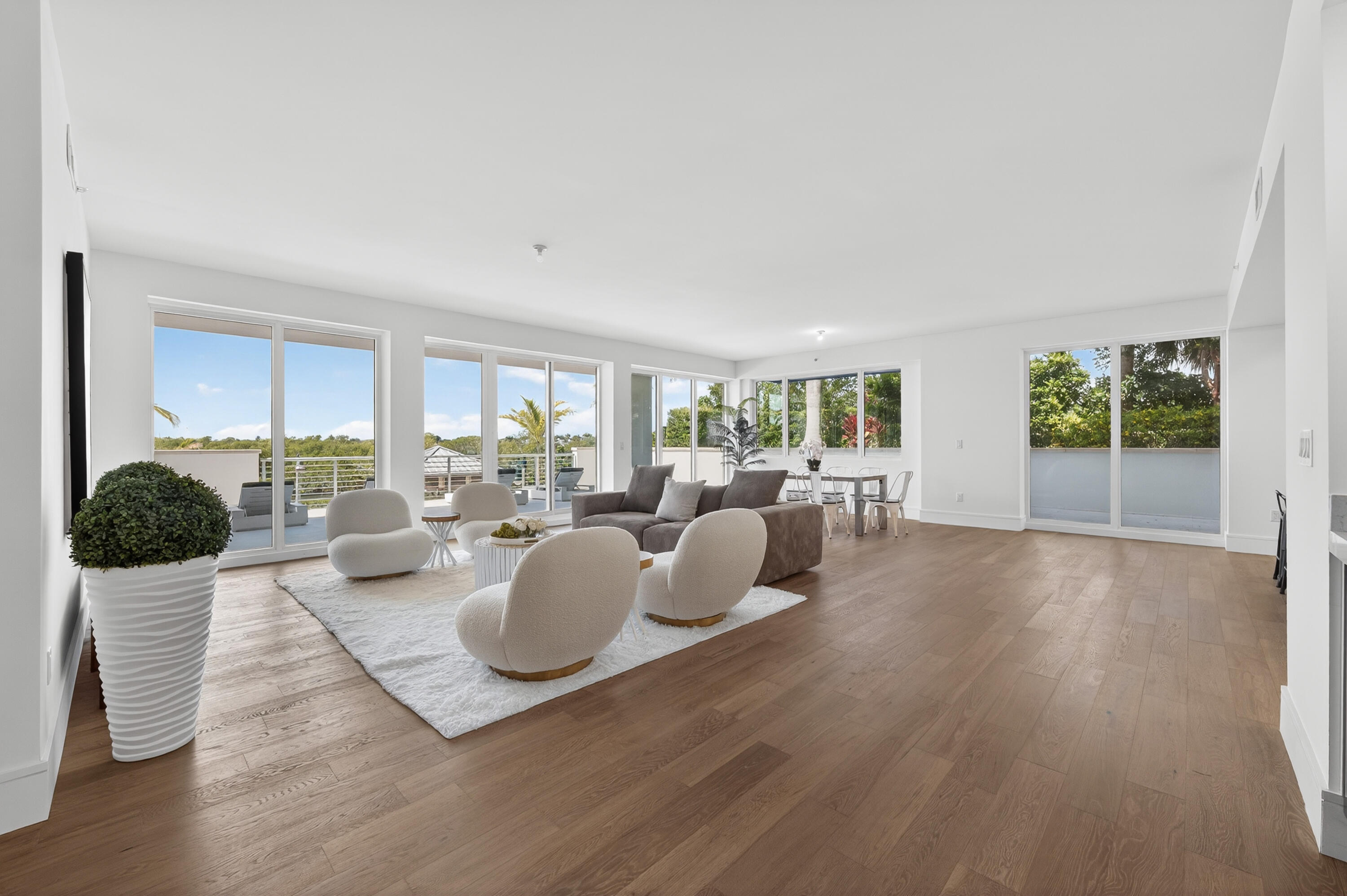 1 South Coastal Way, Unit 201 Jupiter, FL 33477 - Photo 4 of 40 a large living room with furniture a chandelier and a wooden floor