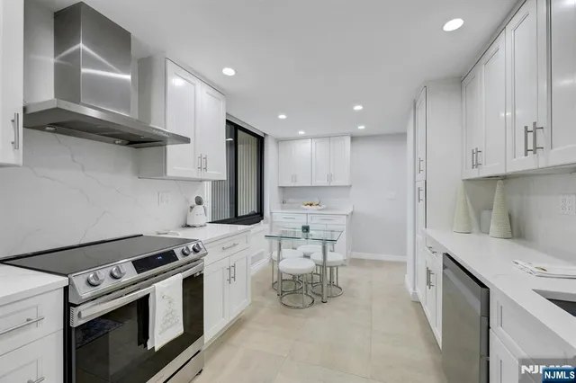 a kitchen with stainless steel appliances a white stove top oven and cabinets