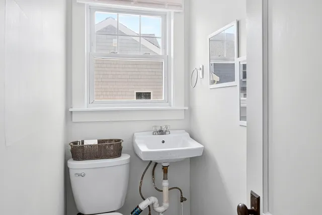 a bathroom with a sink a toilet and a window