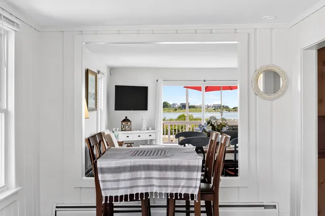 a living room with furniture a flat screen tv and a floor to ceiling window