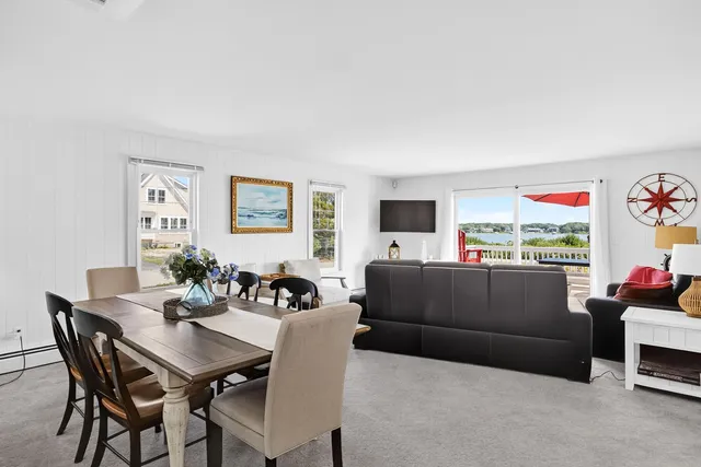 a living room with furniture kitchen view and a window