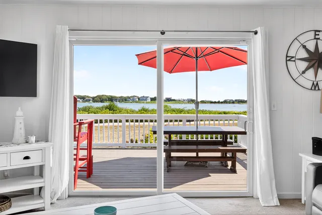 a view of a balcony with chairs and an umbrella
