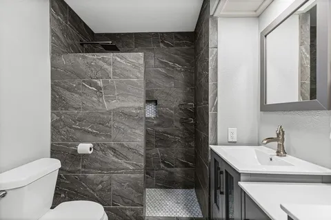 a bathroom with a sink toilet and shower