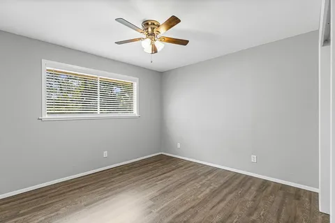 an empty room with a window and a ceiling fan