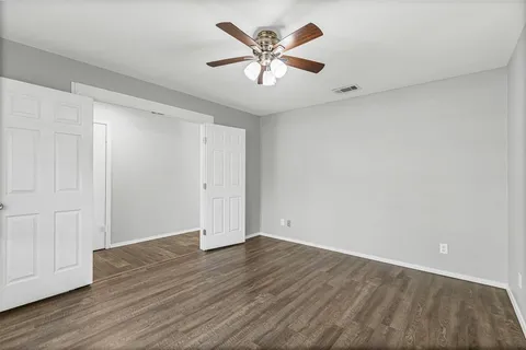 a view of an empty room with wooden floor
