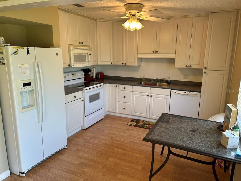 3424 Unity Tree Drive Edgewater, FL 32141 - Photo 12 of 34 a kitchen with stainless steel appliances a stove a refrigerator white cabinets and a refrigerator