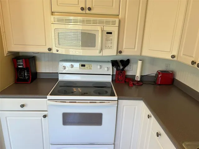 a kitchen with stainless steel appliances a stove a microwave and cabinets