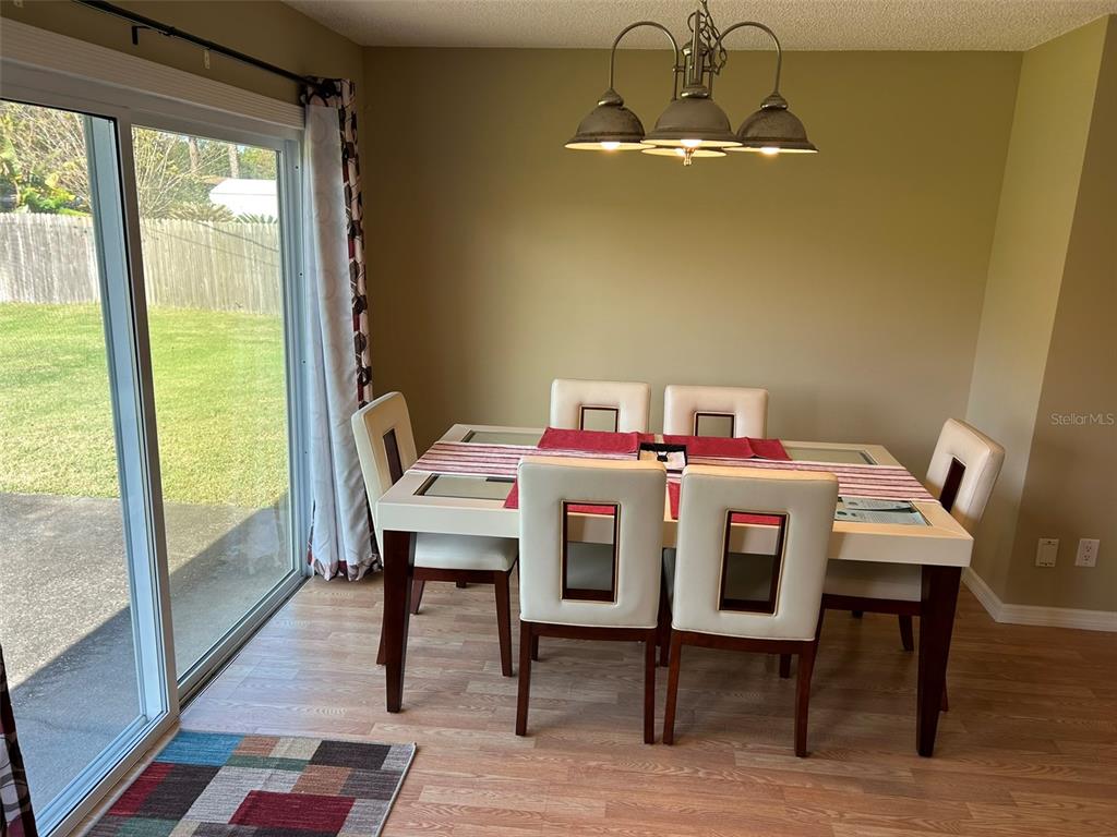 3424 Unity Tree Drive Edgewater, FL 32141 - Photo 14 of 34 a view of a dining room with furniture window and wooden floor