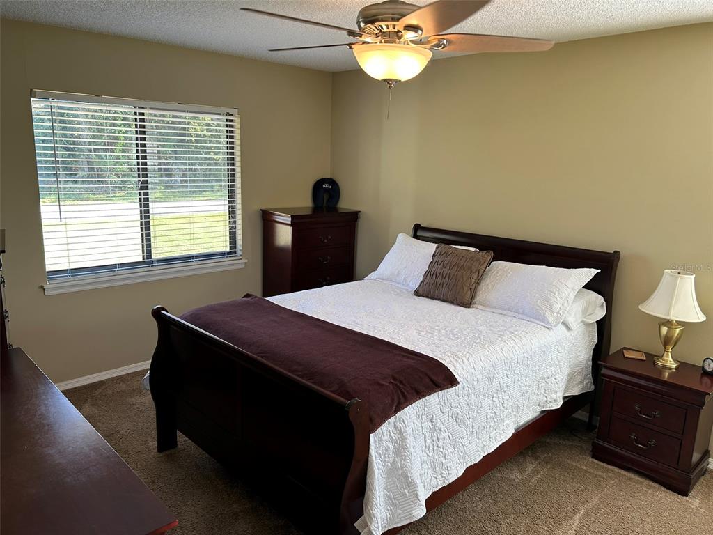 3424 Unity Tree Drive Edgewater, FL 32141 - Photo 19 of 34 a bedroom with a bed and a chandelier
