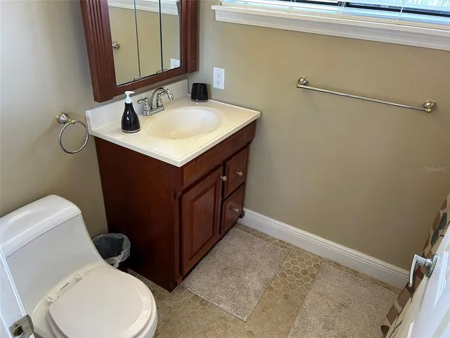 a bathroom with a sink vanity mirror and toilet