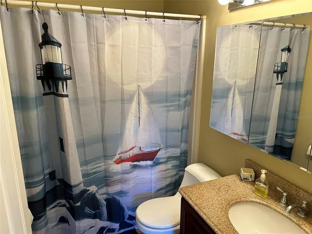a bathroom with a granite countertop sink toilet and shower
