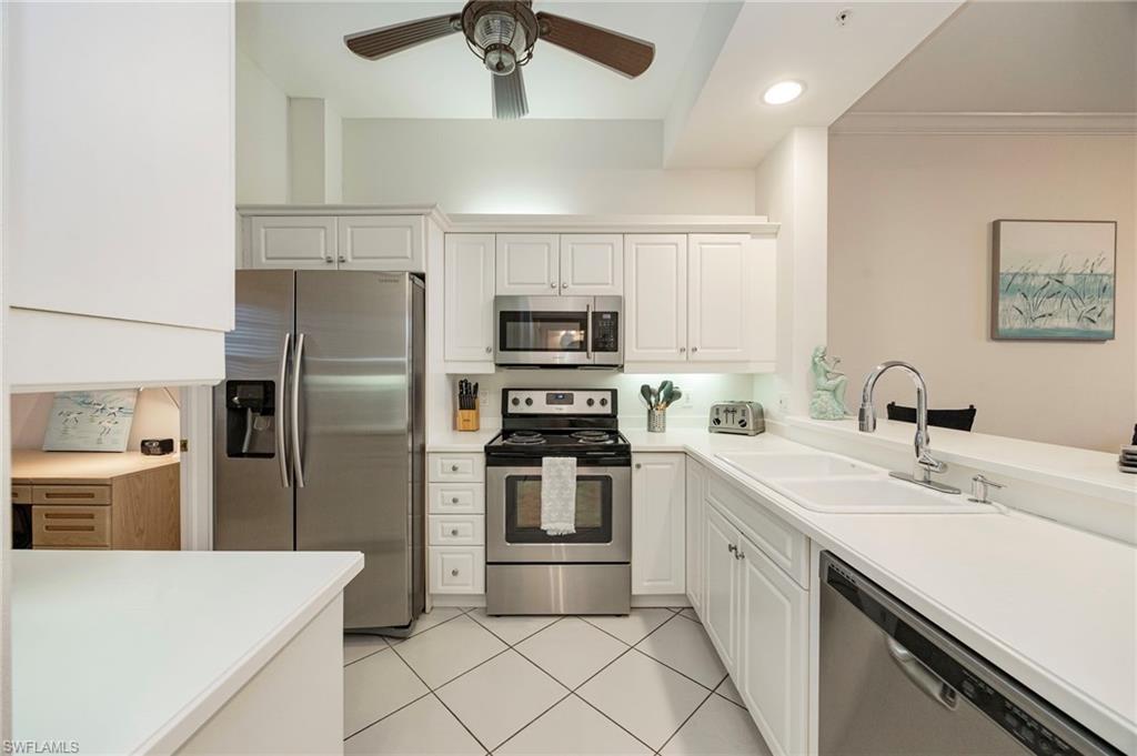410 Bayfront Place, Unit 2502 Naples, FL 34102 - Photo 4 of 21 a kitchen with stainless steel appliances a refrigerator sink and microwave