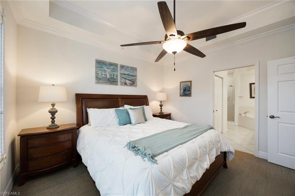 410 Bayfront Place, Unit 2502 Naples, FL 34102 - Photo 6 of 21 a bedroom with a bed and a chandelier