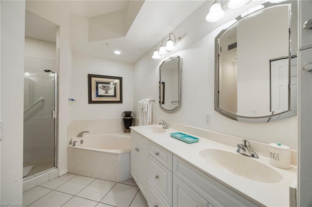 410 Bayfront Place, Unit 2502 Naples, FL 34102 - Photo 7 of 21 a bathroom with a tub a double vanity sink and mirror
