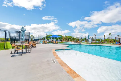 a view of a swimming pool with a yard and plants