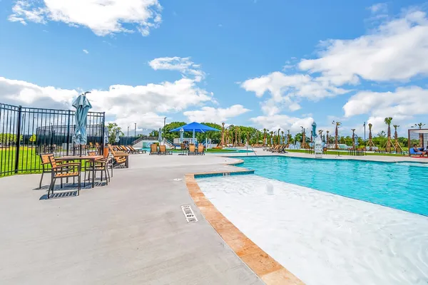 a view of a swimming pool with a yard and plants