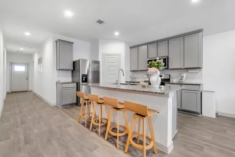 a kitchen with stainless steel appliances granite countertop a sink stove and refrigerator