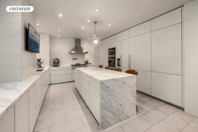 a large white kitchen with a stove a sink and a refrigerator