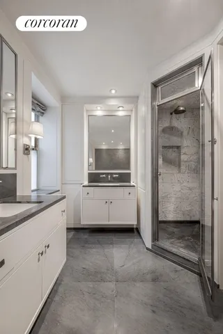 a bathroom with a double vanity sink mirror and bathtub