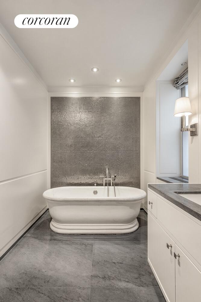 3 East 84th Street, Unit 3 Manhattan, NY 10028 - Photo 19 of 24 a spacious bathroom with a sink a mirror and a bathtub