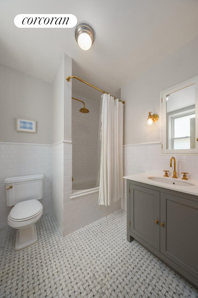 3 East 84th Street, Unit 3 Manhattan, NY 10028 - Photo 21 of 24 a bathroom with a sink a toilet and a mirror