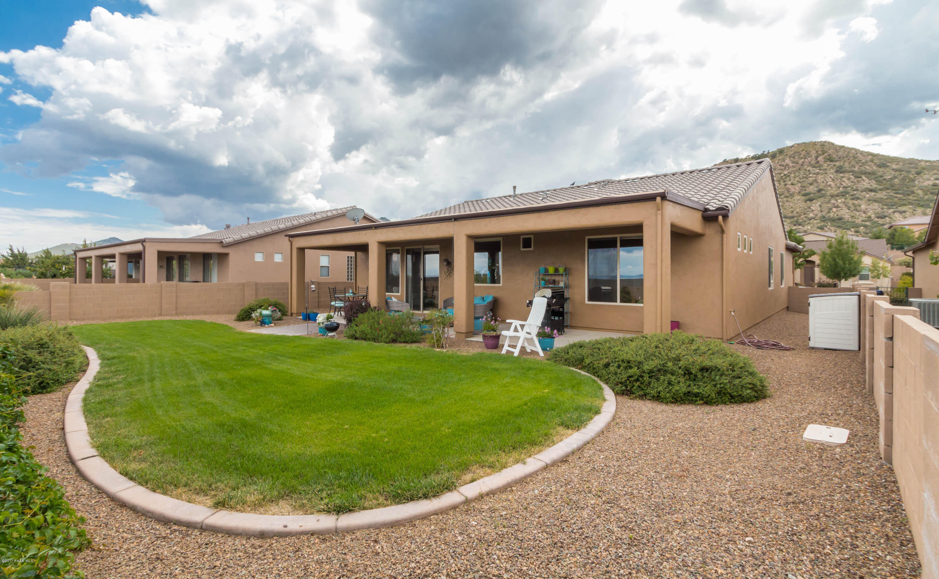 1197 Rusty Nail Road Prescott Valley, AZ 86314 - Photo 17 of 40 a view of a white house with a swimming pool and a yard